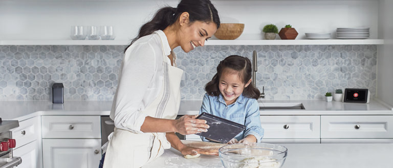 mother and daughter in kitchen looking at tablet
